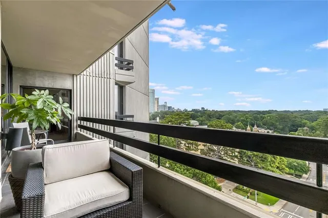a view of a balcony with chairs and a potted plant