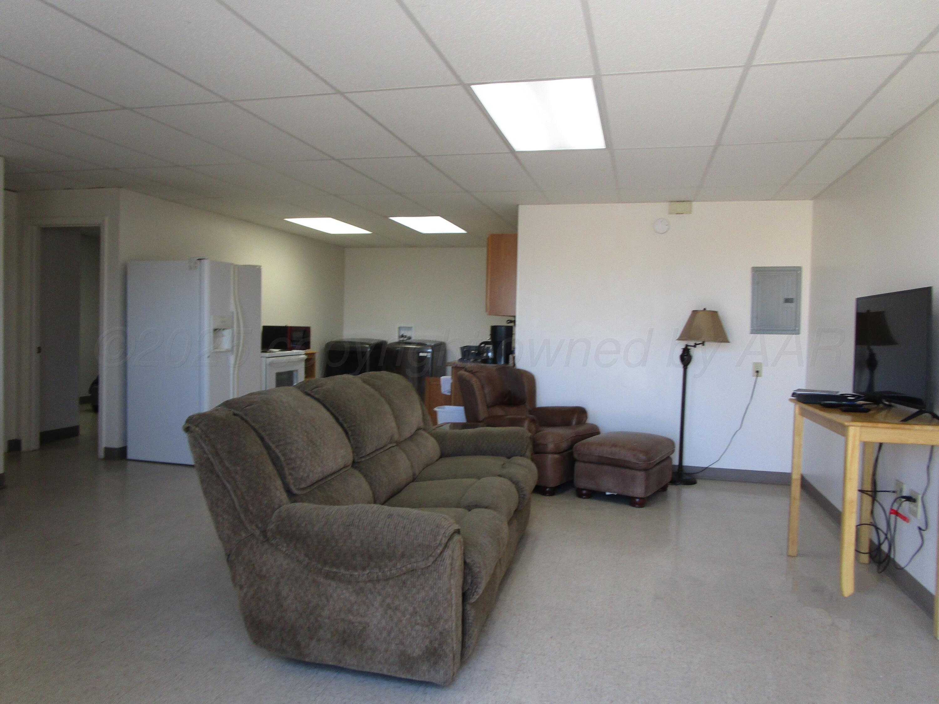 704 Deahl Street Borger, TX 79007 - Photo 2 of 8 a living room with furniture a flat screen tv and gym equipment