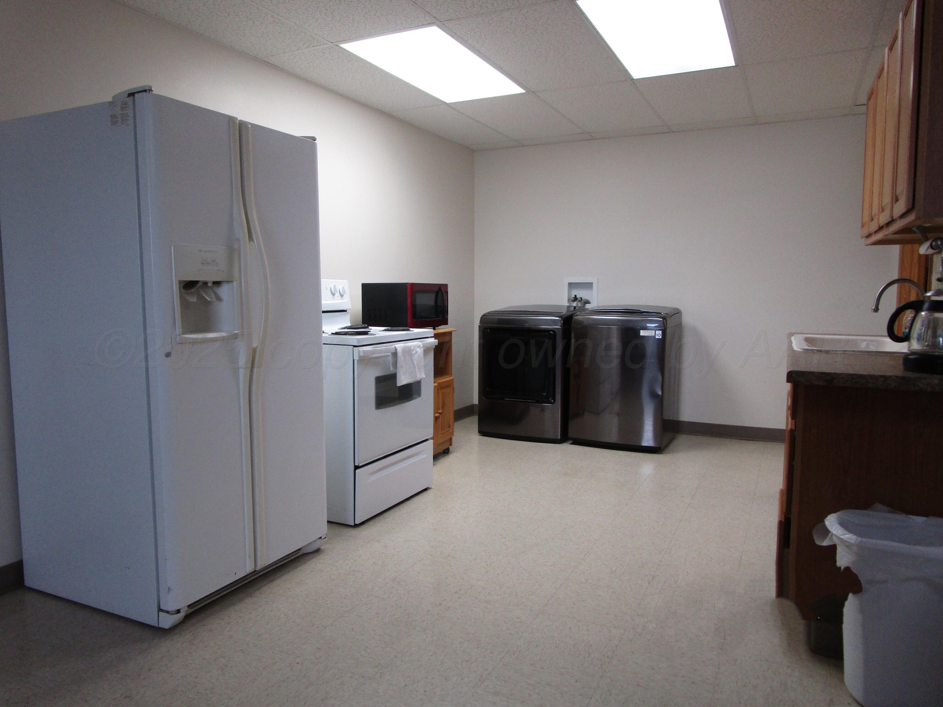 704 Deahl Street Borger, TX 79007 - Photo 3 of 8 a kitchen with cabinets and white stainless steel appliances