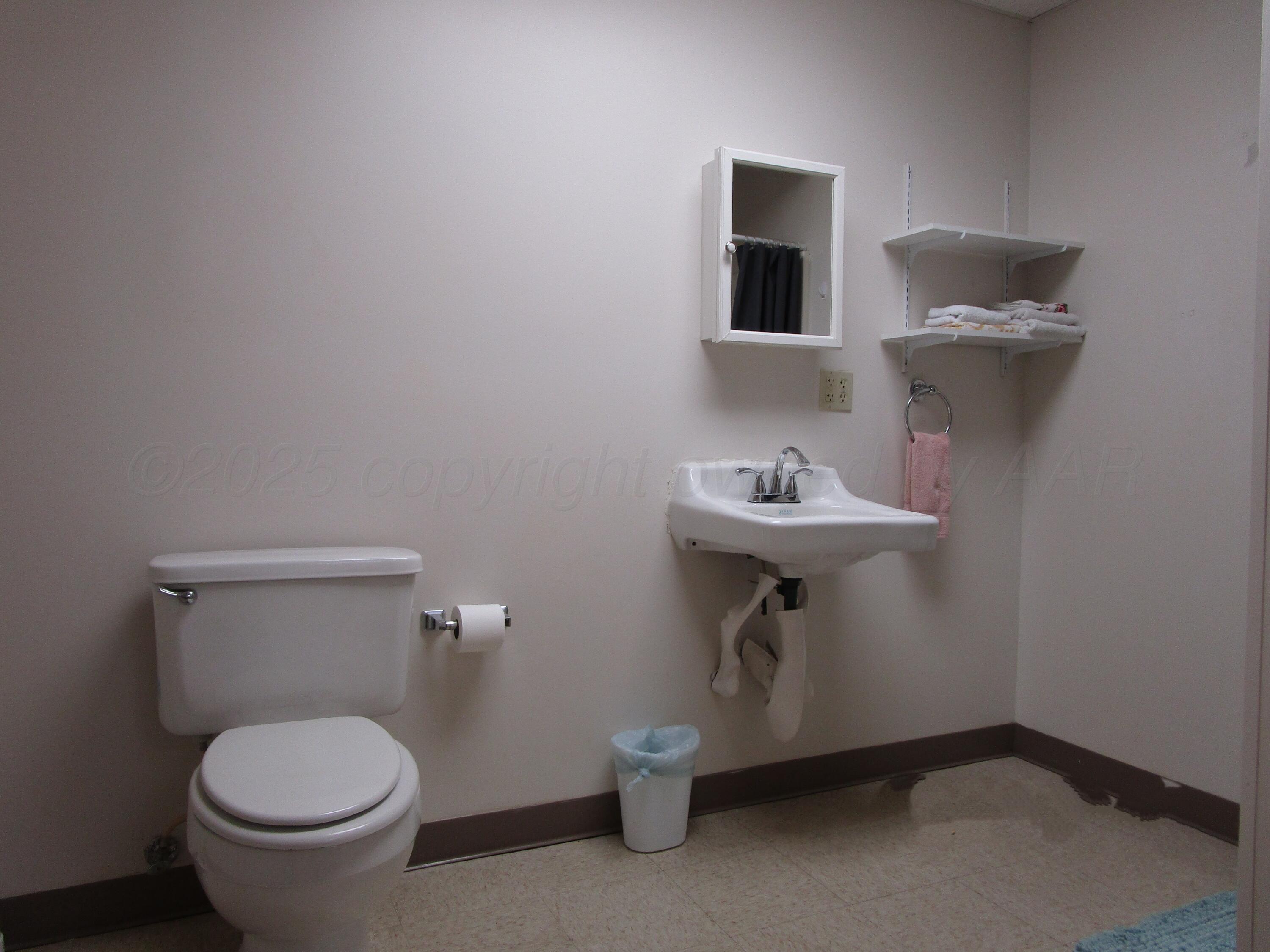 704 Deahl Street Borger, TX 79007 - Photo 7 of 8 a bathroom with a sink toilet and a mirror