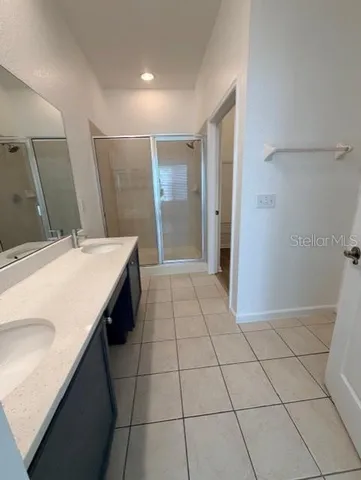 a bathroom with a double vanity sink a mirror and a shower