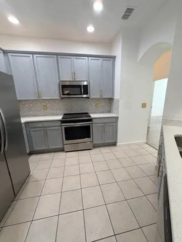 a kitchen with stainless steel appliances a sink a stove a microwave and cabinets