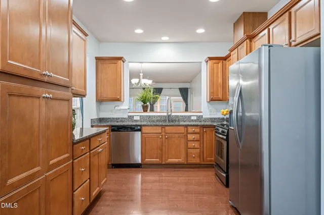 a large kitchen with stainless steel appliances a refrigerator and cabinets