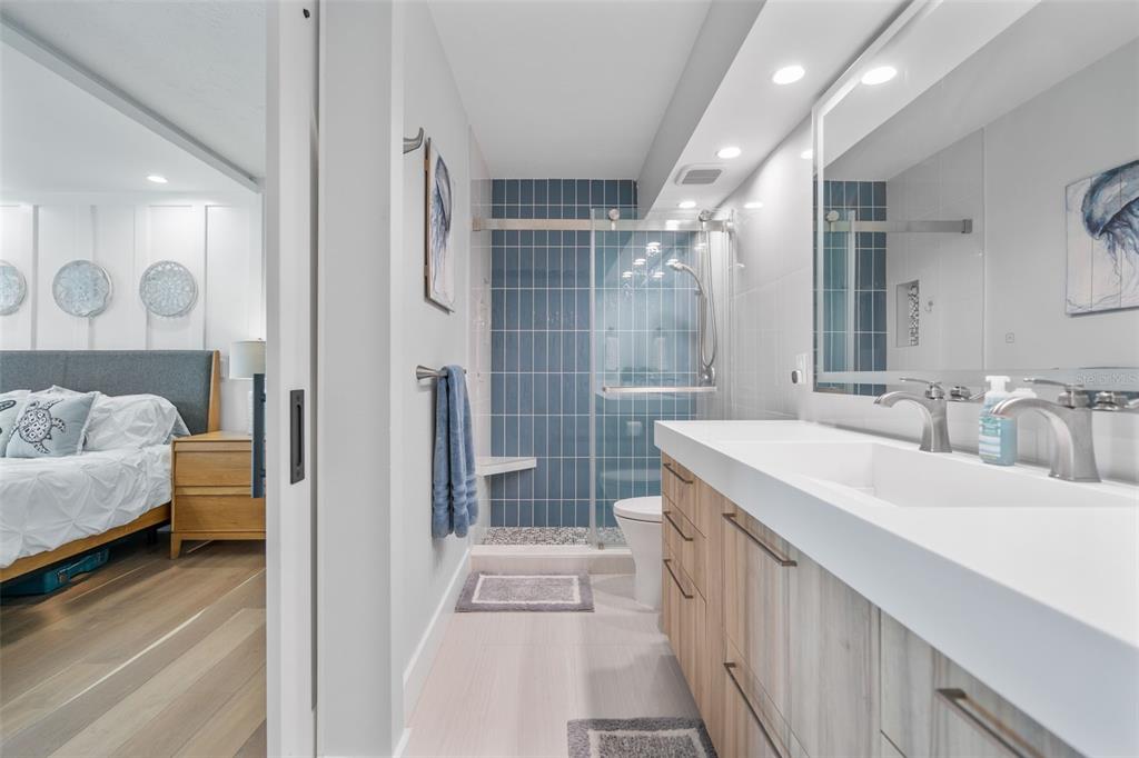 1050 Longboat Club Road, Unit 901 Longboat Key, FL 34228 - Photo 20 of 37 a en suite bathroom with a double vanity sink a mirror and shower