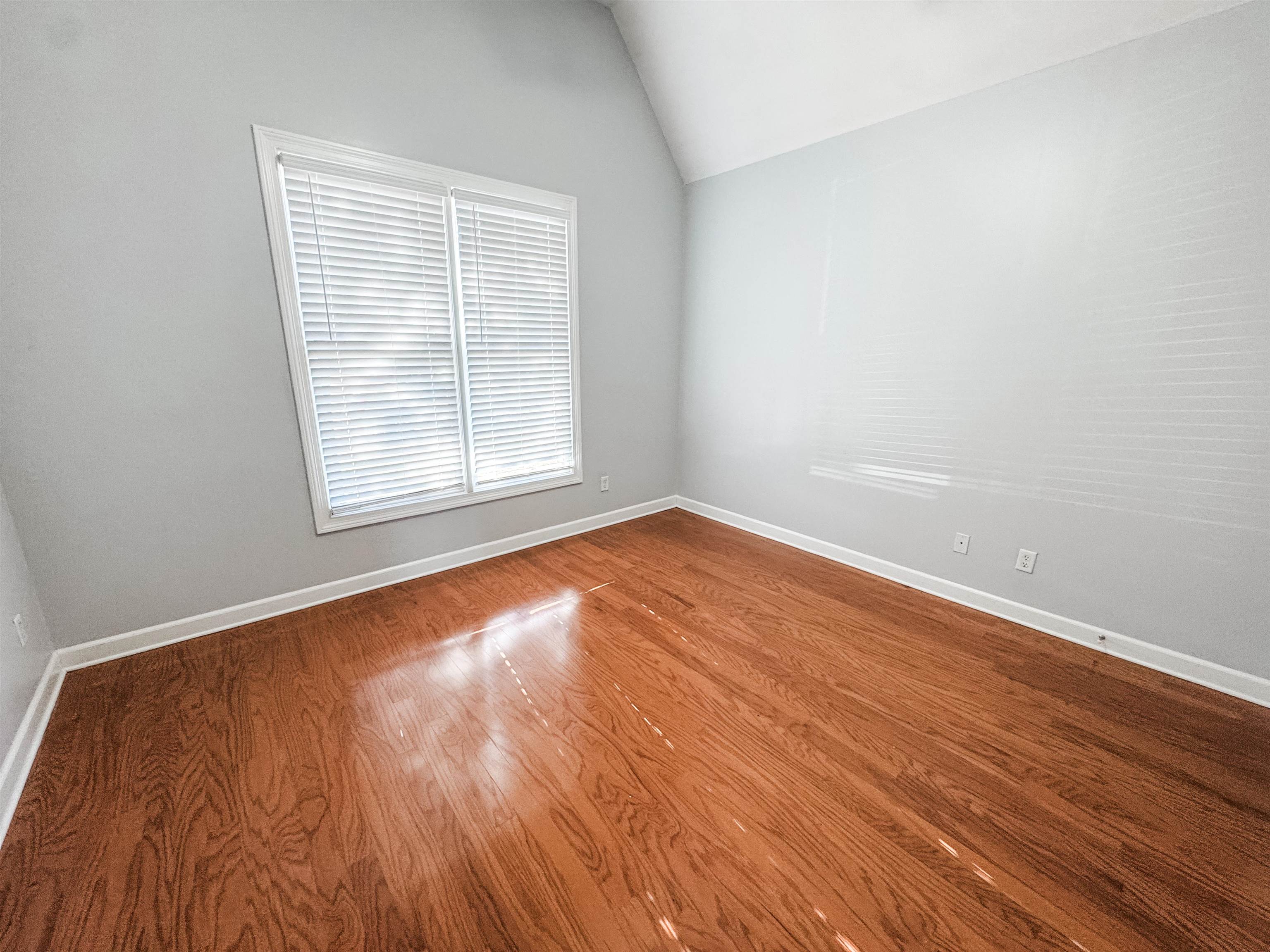 472 Hunters Mill Cove Collierville, TN 38017 - Photo 8 of 15 an empty room with wooden floor and windows
