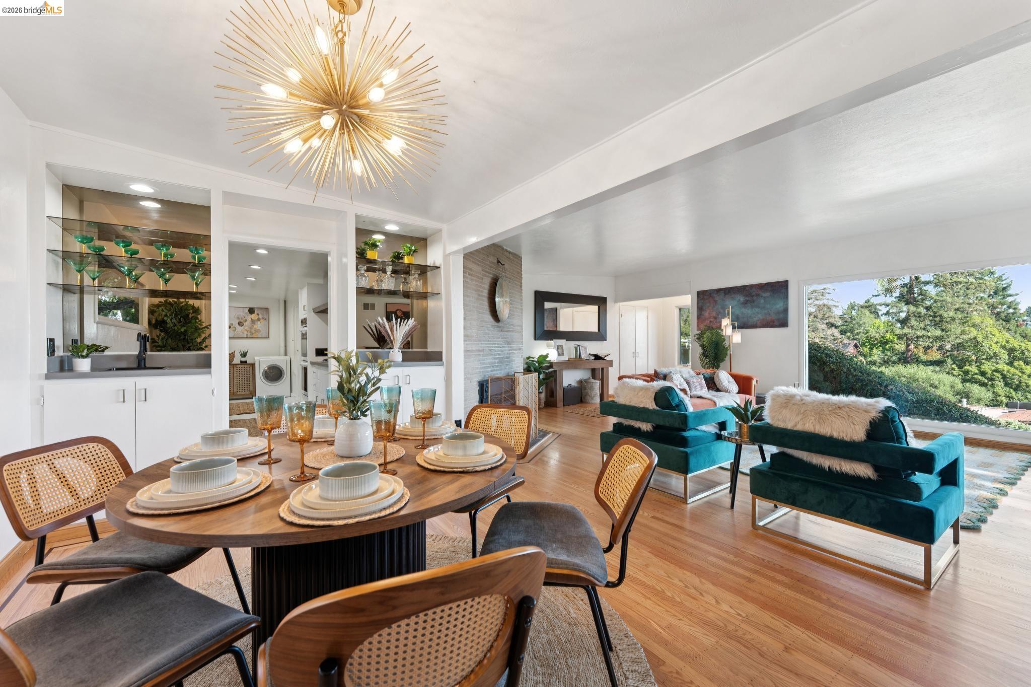 2301 Oak Street Berkeley, CA 94708 - Photo 5 of 61 Open-concept living area featuring wood-finish flooring, a contemporary chandelier, and a built-in wet bar with shelving