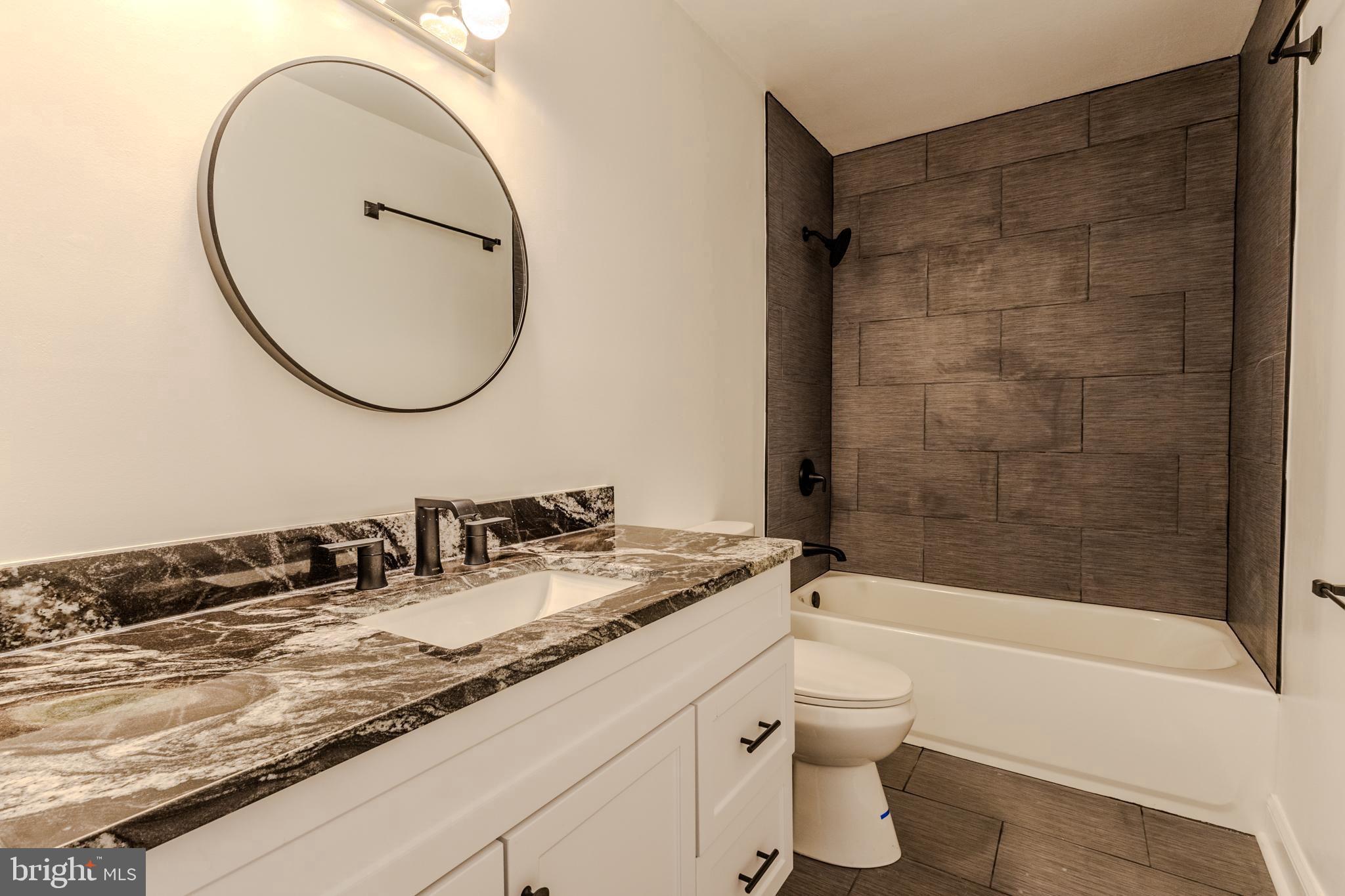 524 Ridge Road Annapolis, MD 21401 - Photo 9 of 17 a bathroom with a granite countertop sink a toilet and a mirror