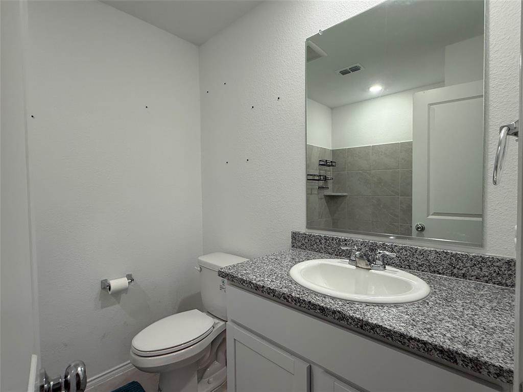 330 Ashbrook Way Princeton, TX 75407 - Photo 10 of 11 a bathroom with a granite countertop sink a toilet and a mirror