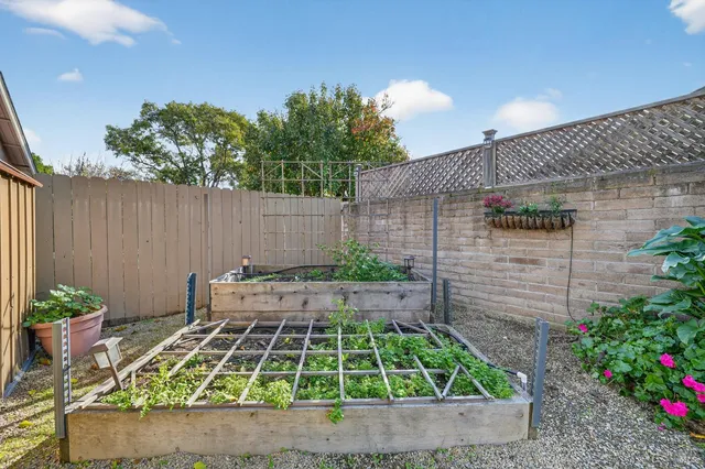 a view of backyard with a table and chairs with wooden fence