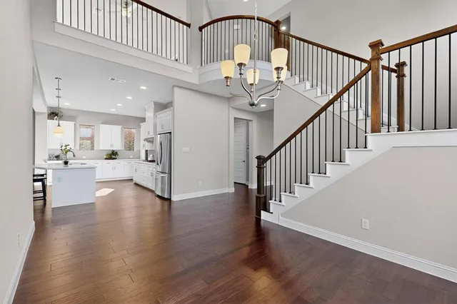 an empty room with wooden floor a fireplace and windows