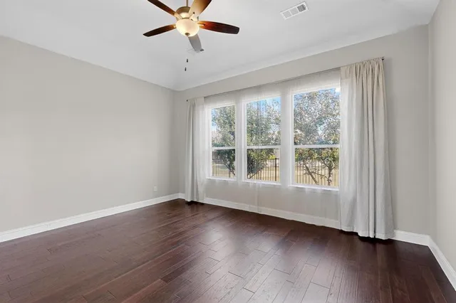 a view of an entryway with wooden floor and a kitchen view