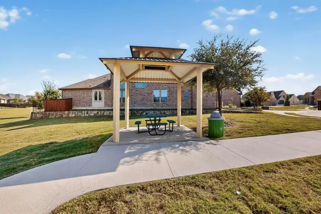 a view of house with a yard and a large tree