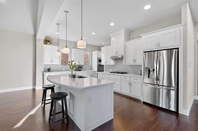 a kitchen with kitchen island white cabinets and stainless steel appliances