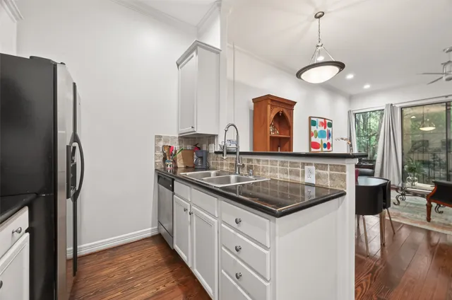 a kitchen with stainless steel appliances granite countertop a sink and a refrigerator