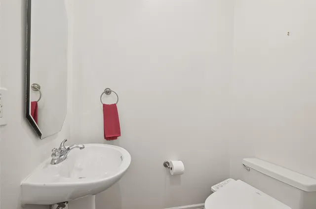 a bathroom with a sink mirror and toilet