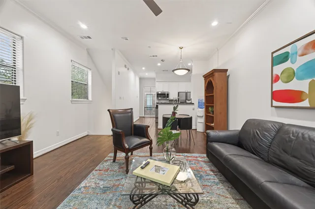 a living room with furniture kitchen view and a flat screen tv