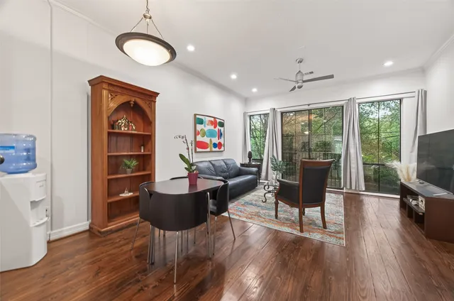 a living room with furniture a flat screen tv and wooden floor
