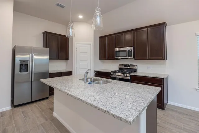 a kitchen with a stove and a wooden floor