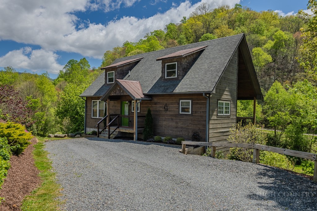 210 Grand Creek Road Vilas, NC 28692 - Photo 1 of 40 a view of a house with a yard and table and chairs under an umbrella