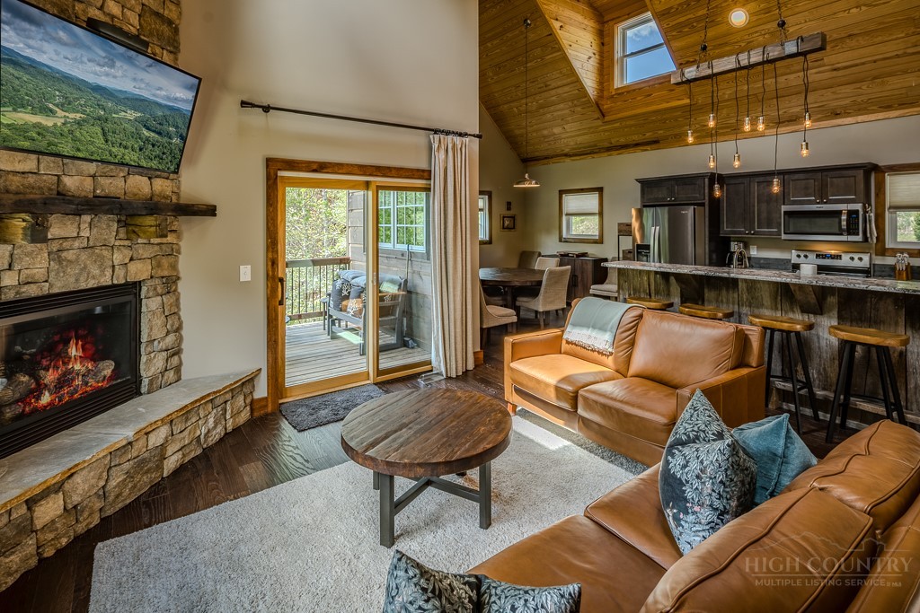 210 Grand Creek Road Vilas, NC 28692 - Photo 8 of 40 a living room with furniture a flat screen tv and a fireplace