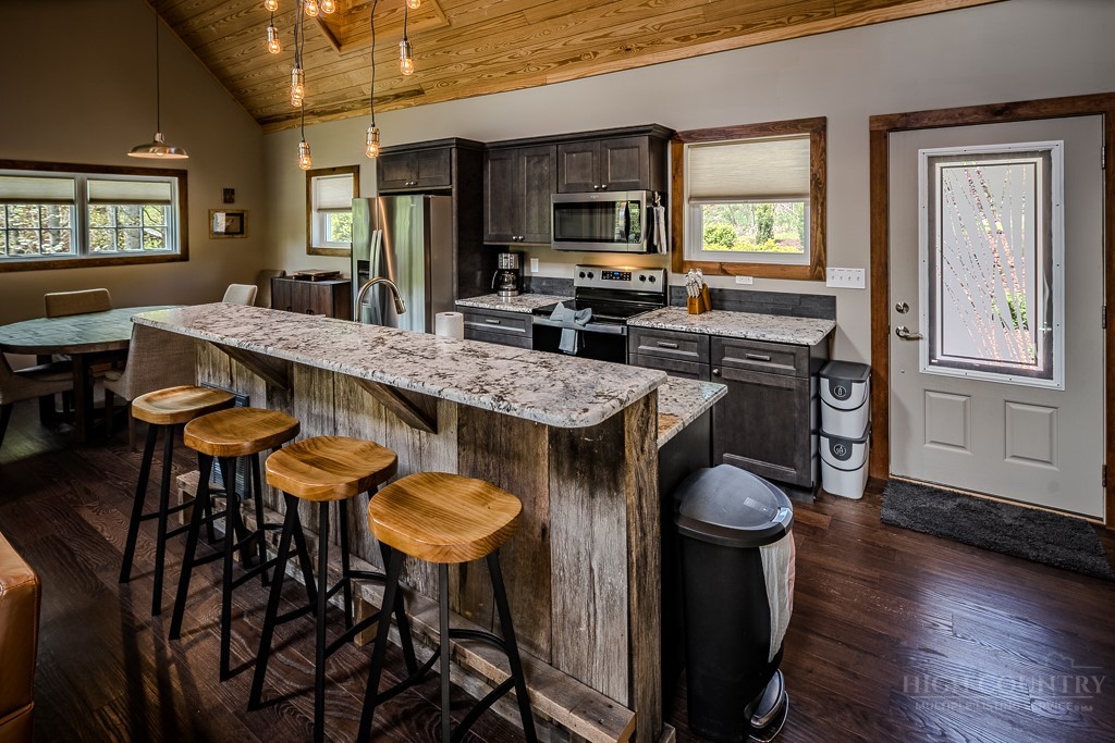 210 Grand Creek Road Vilas, NC 28692 - Photo 9 of 40 a kitchen with a table chairs refrigerator and sink