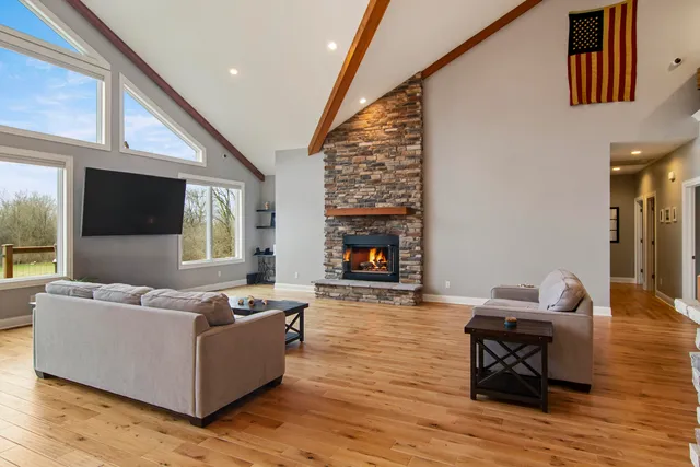 a kitchen with stainless steel appliances granite countertop a dining table chairs refrigerator and cabinets