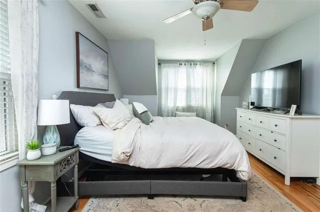 a bedroom with a bed window and a flat screen tv