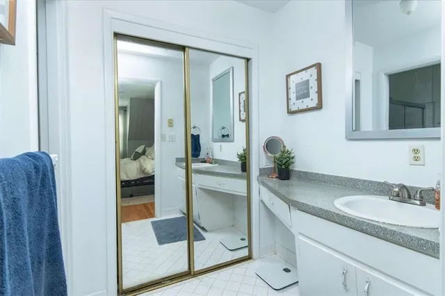 a en suite bathroom with a granite countertop sink and a mirror