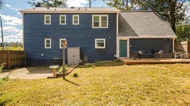 a view of a house with backyard and sitting area