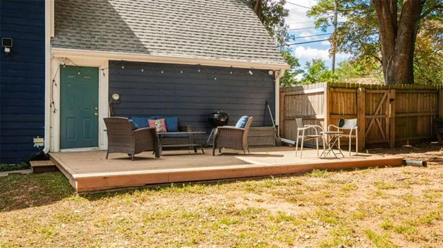 a view of a patio with table and chairs with wooden floor and fence