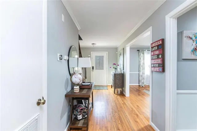 a view of a hallway with wooden floor and furniture