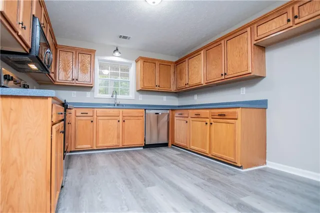 an empty room with wooden floor and a ceiling fan