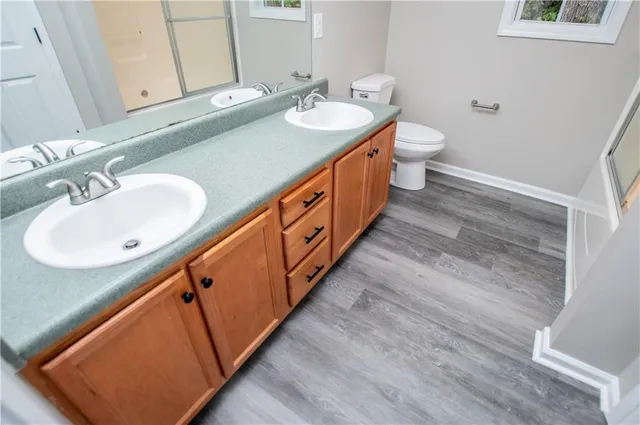 a bathroom with a sink a toilet and a mirror