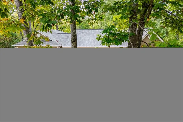 an aerial view of a house with swimming pool and large trees