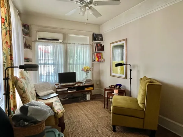 a living room with furniture a flat screen tv and a window