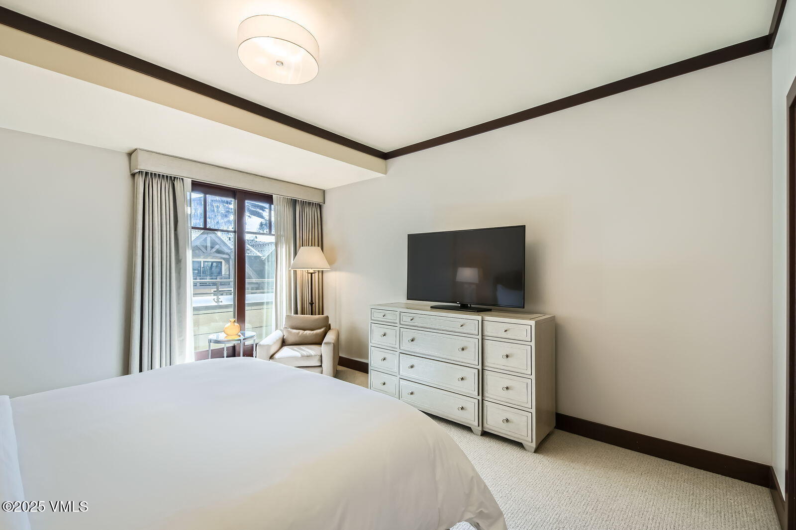 1 Vail Road, Unit 8101F Vail, CO 81657 - Photo 15 of 28 a bedroom with a bed and a flat tv screen on dresser