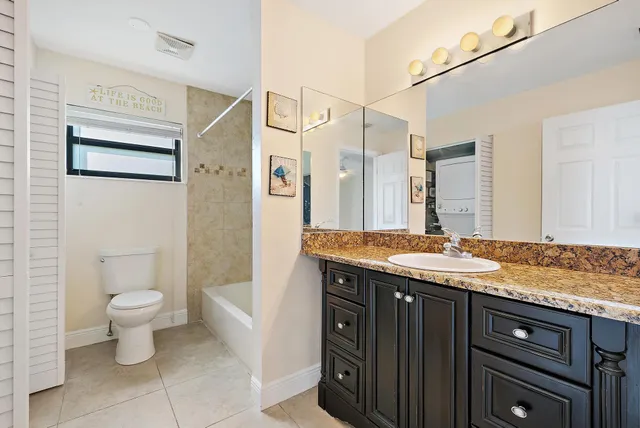 a spacious bathroom with a granite countertop sink toilet and shower