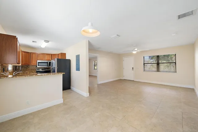 a view of a kitchen with refrigerator and a stove top oven