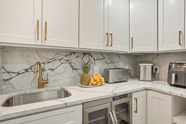 a kitchen with white cabinets and a sink