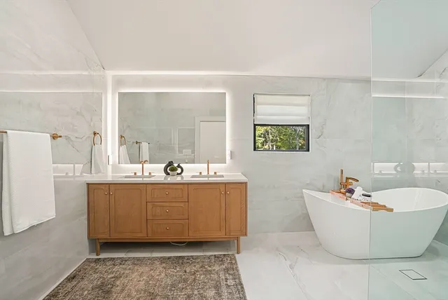 a bathroom with a tub sink and mirror