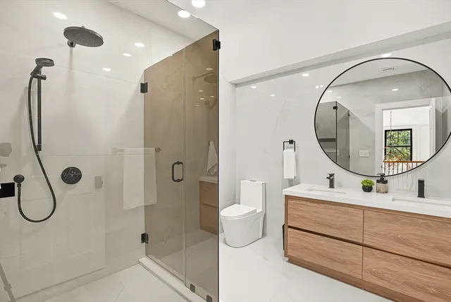 a bathroom with a sink mirror toilet and shower