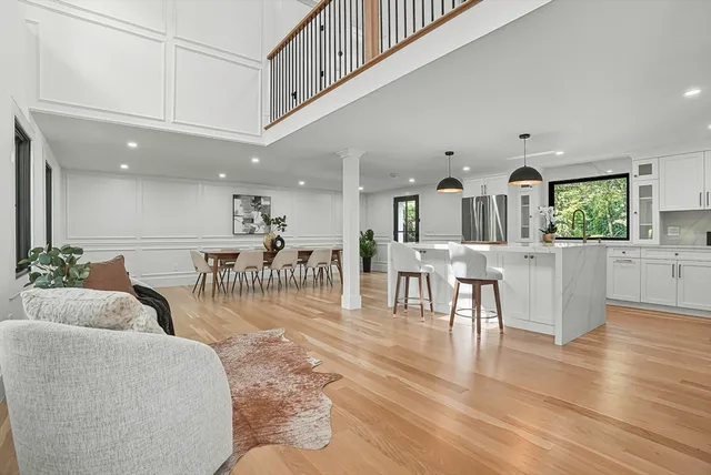 a living room with furniture and a dining table with wooden floor