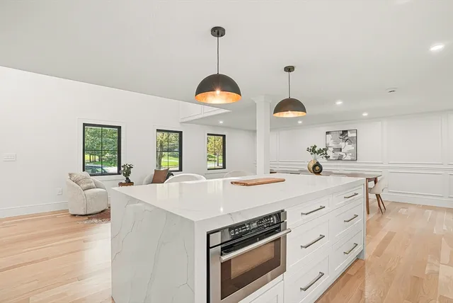 a large kitchen with stainless steel appliances a stove oven and wooden floor