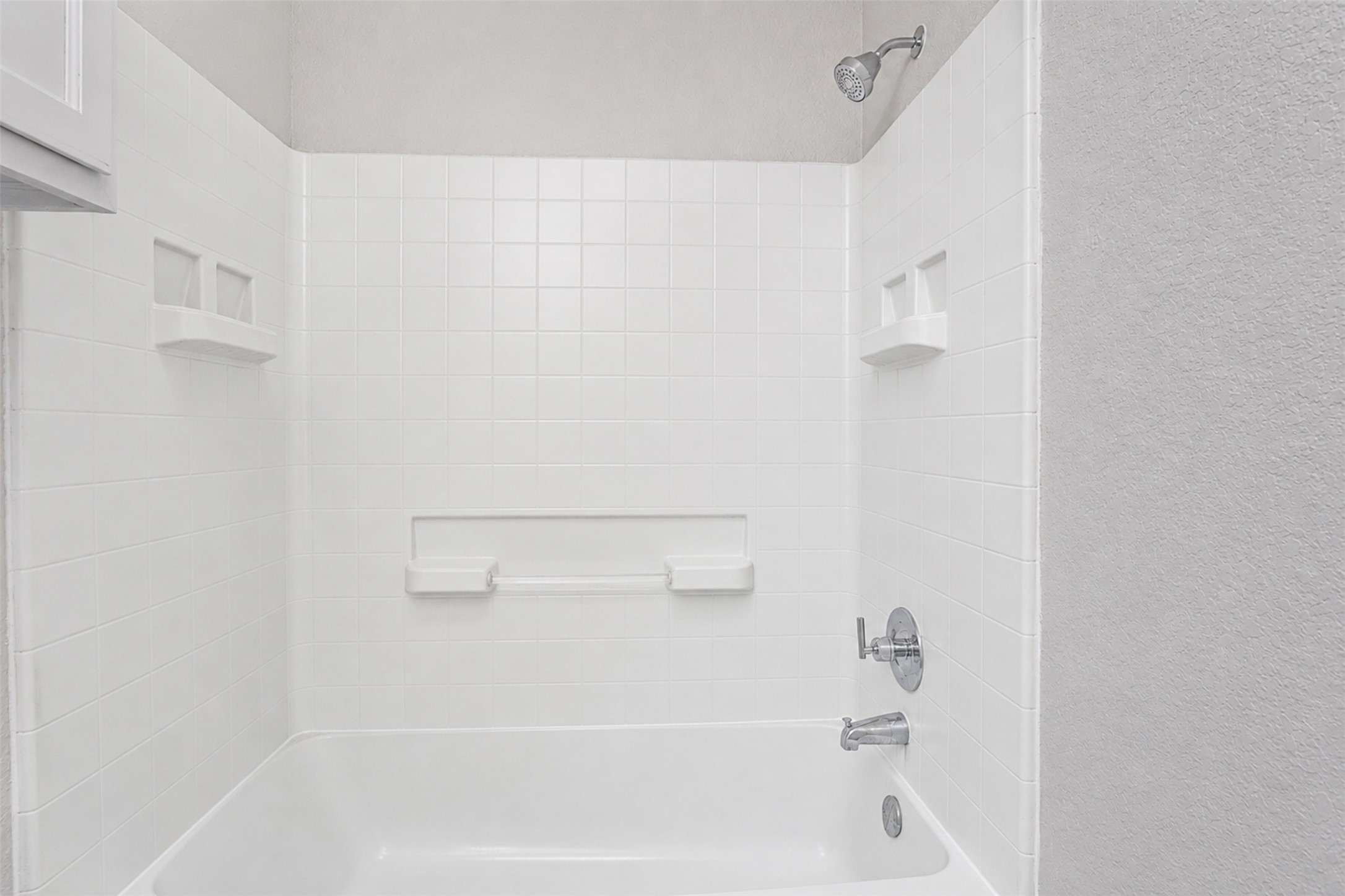 4523 Secure Lane Austin, TX 78725 - Photo 36 of 40 A pristine bath and shower area features gleaming white tile and convenient built-in shelving.