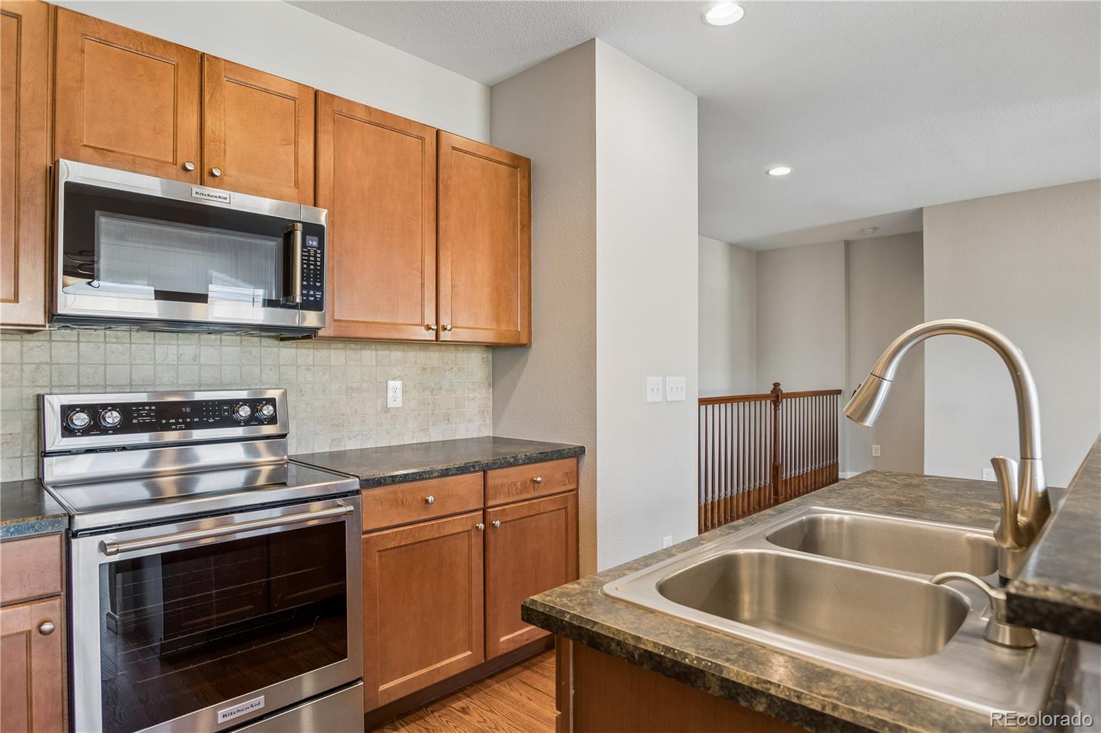 5031 South Rome Street Aurora, CO 80015 - Photo 11 of 39 a kitchen with a sink stove and microwave