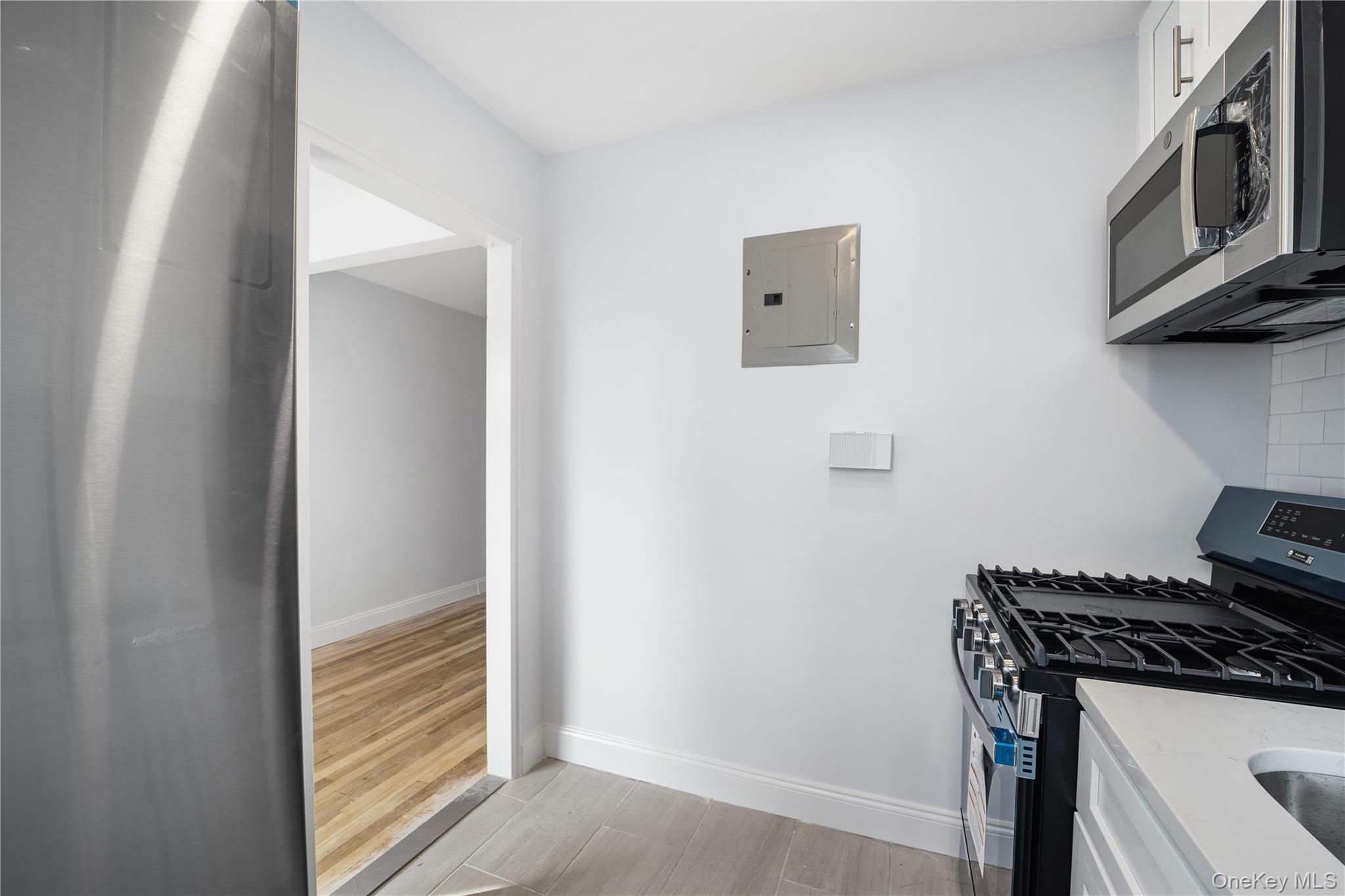 228-08 Stronghurst Avenue, Unit LOWR Queens, NY 11427 - Photo 11 of 20 a kitchen with stainless steel appliances a stove and a microwave