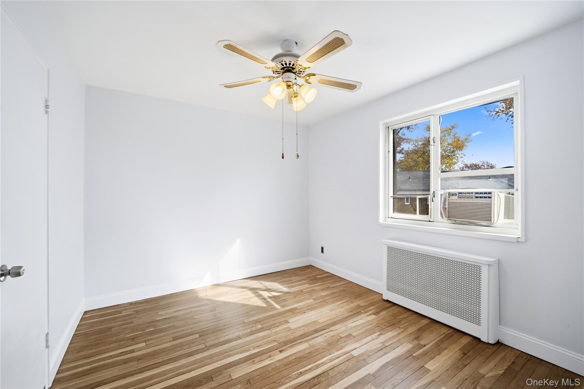 228-08 Stronghurst Avenue, Unit LOWR Queens, NY 11427 - Photo 16 of 20 a view of a livingroom with a window and wooden floor