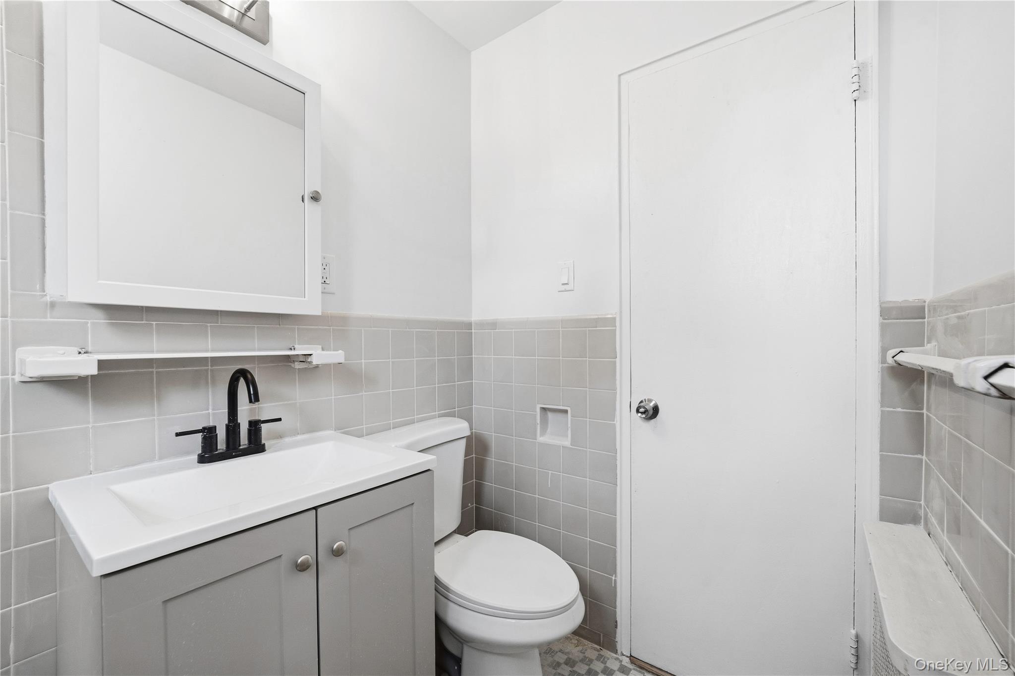 228-08 Stronghurst Avenue, Unit LOWR Queens, NY 11427 - Photo 18 of 20 a bathroom with a toilet sink and mirror
