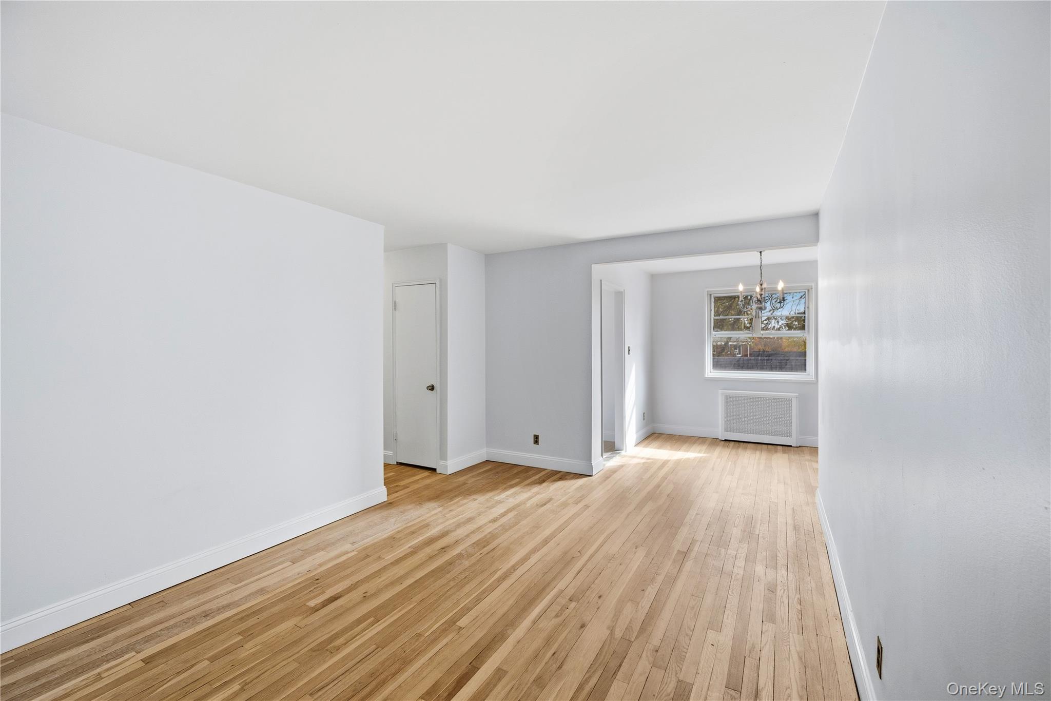 228-08 Stronghurst Avenue, Unit LOWR Queens, NY 11427 - Photo 4 of 20 a view of an empty room with wooden floor and a window