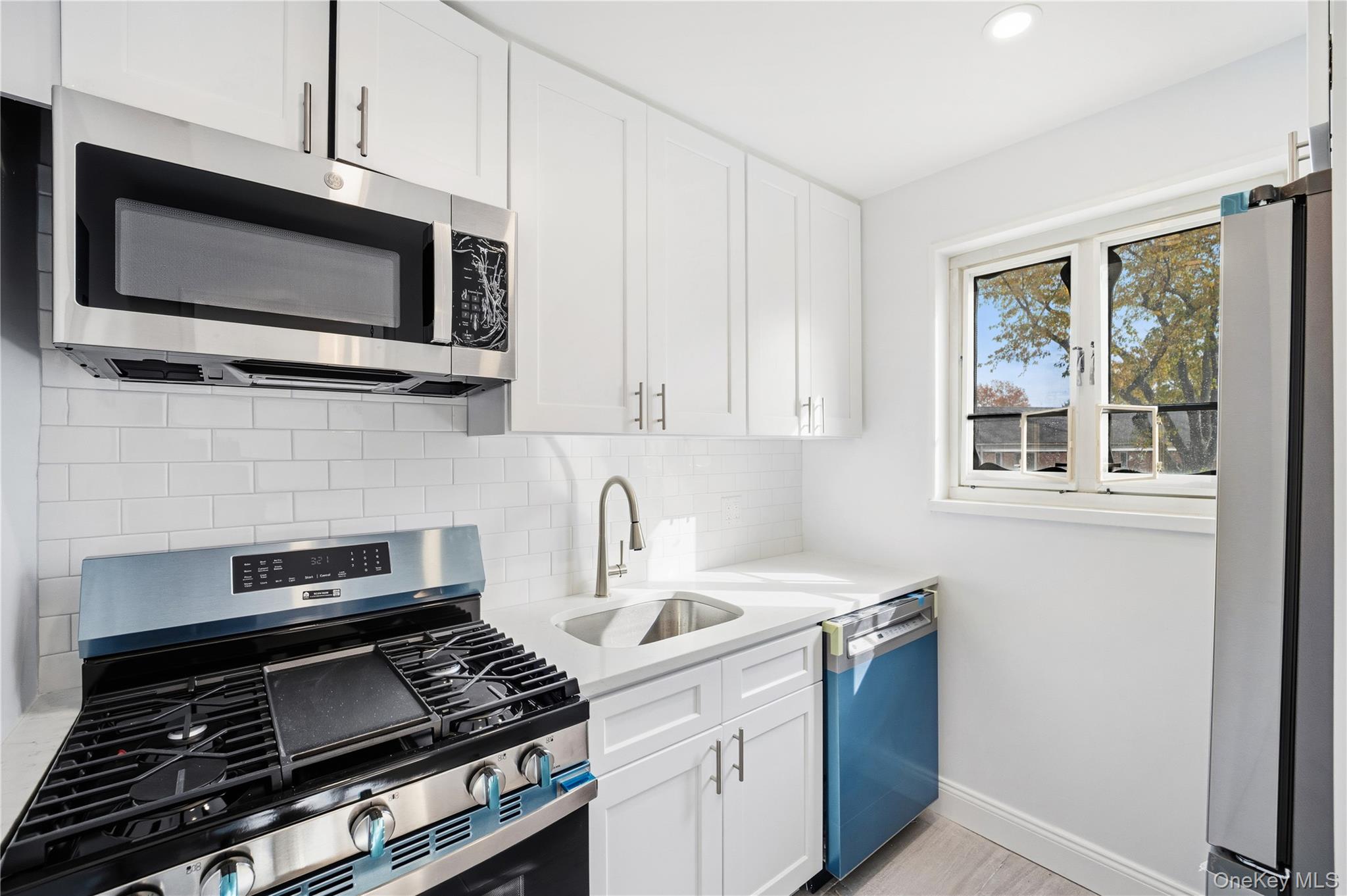 228-08 Stronghurst Avenue, Unit LOWR Queens, NY 11427 - Photo 9 of 20 a kitchen with a stove and a microwave